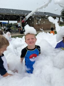 Kid playing in foam bubbles